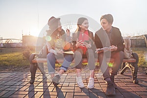 Group of Asian teenage students schoolchildren sitting on a bench in the park and preparing exams