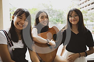 Group of asian teenager standing outdoor plying spanish guitar photo