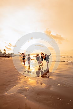 a group of Asian teenagers running with happy expressions on vacation with their friends drunk on the beach