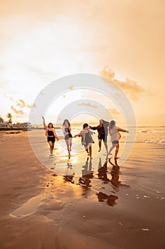 a group of Asian teenagers running with happy expressions on vacation with their friends drunk on the beach