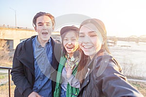 Group of Asian teens taking selfie on phone, having fun, best friends and digital generation concept