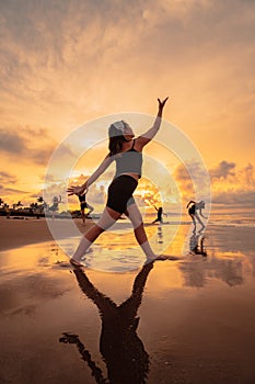 a group of Asian women dancing ballet together and in unison before the festival starts on the beach