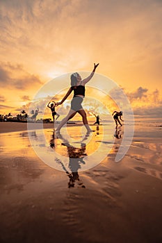 a group of Asian women dancing ballet together and in unison before the festival starts on the beach