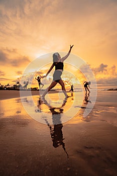 a group of Asian women dancing ballet together and in unison before the festival starts on the beach