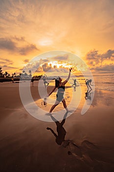 a group of Asian women dancing together and full of joy on the beach