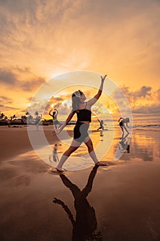 a group of Asian women dancing together and full of joy on the beach