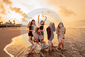 a group of Asian women enjoying their holiday very crazy with their friends and with a full expression of silliness on the beach photo