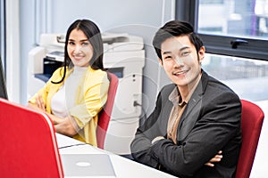 Group of Asian young business man and woman working on computer in office. Portrait of people in casual suit cross arm sitting on