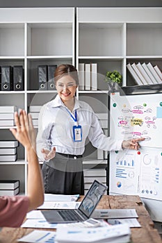 Group of asian young modern people in smart casual wear having a brainstorm meeting while sitting in office background