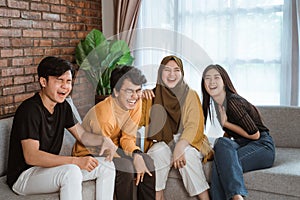 Group of Asian young people sitting together on the couch laughing together