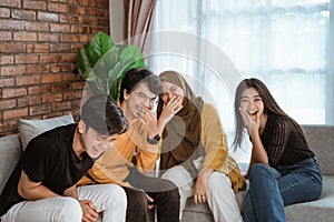 Group of Asian young people sitting together on the couch laughing together