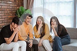 Group of Asian young people sitting together on the couch laughing together