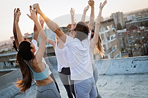 Group of athletic young people, friends in sportswear doing exercises. Sport outdoors