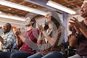 Group Attending Neighborhood Meeting In Community Center Clapping