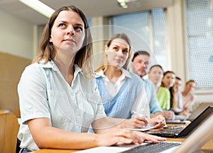 Group of attentive students writes synopsis in copybooks