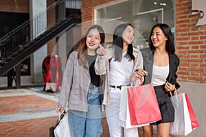 Group of attractive Asian girls with shopping bags are enjoying shopping in the city