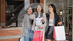 Group of attractive Asian girls with shopping bags are enjoying shopping in the city