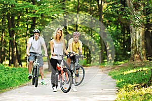 Group of attractive happy people on bicycles in the countryside