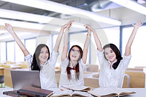 Group of attractive students raise hands