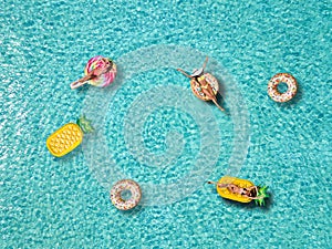 A group of attractive woman enjoys the sun on shaped floats