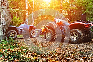 A group of ATVs in a forest covered in mud. Wheels and elements of all-terrain vehicles in mud and clay. Active leisure, sports