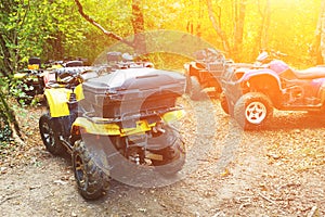 A group of ATVs in a forest covered in mud. Wheels and elements of all-terrain vehicles in mud and clay. Active leisure, sports