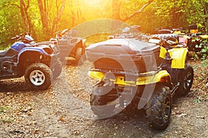 A group of ATVs in a forest covered in mud. Wheels and elements of all-terrain vehicles in mud and clay. Active leisure, sports