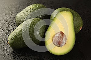 Group of avocado with half on black background