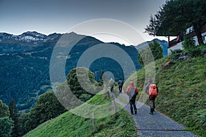 Group of backpacker hiking on trail in Swiss Alps valley on summit