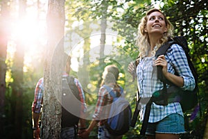 Group of backpacking hikers going for forest trekking