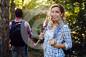 Group of backpacking hikers going for forest trekking