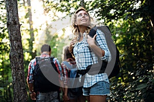 Group of backpacking hikers going for forest trekking