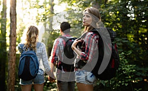 Group of backpacking hikers going for forest trekking