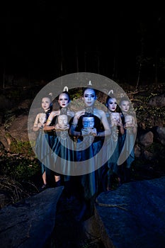 A Group of Balinese woman line up with the wooden mask in their hands while wearing a traditional dance costumes