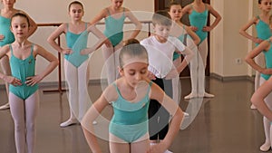 Group of ballet girls doing stretching exercises before dance lessons.