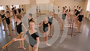 Group of ballet girls doing stretching exercises before dance lessons.