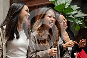 Group of beautiful young Asian girls are laughing and enjoying shopping in the city shopping street