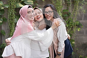 Group of best fiend muslim girl smiling at camera while hugging photo