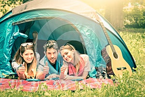 Group of best friends with thumbs up in camping tent