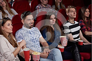 Group of best friends watching new film at modern cinema.