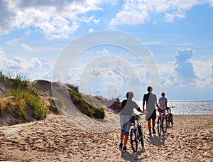 Group with bicycle at seacoast photo