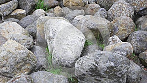 Group of big boulder stones lying in field, natural geologic background