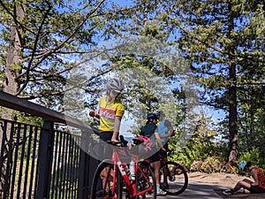 Group of bikers resting at the top of a hill at Snoqualmie Falls Park on a sunny day in the mountains