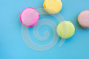 Group of biscuits known as macarons or macaroons on blue backgrouns