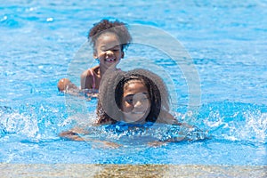 Group of black children happy playing water pool park outdoor in hot summer season