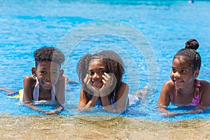 Group of black children happy playing water pool park outdoor in hot summer season