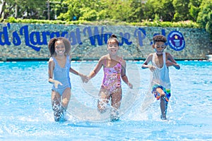 Group of black children happy playing water pool park outdoor in hot summer season