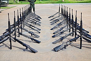 The group of black rifles lay on the cement floor to organize military combat concepts.