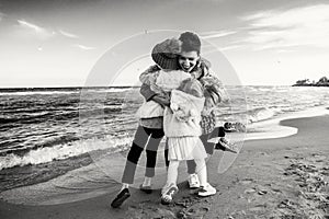 Three funny smiling laughing Caucasian children kids friends playing running on ocean sea beach