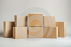 A group of blank cardboard boxes stacked tall in a cascading formation on a white floor